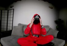 Tattooed Vixen in Red Jumpsuit Flaunts Her Bare Feet for Attention