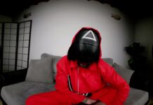 Tattooed Vixen in Red Jumpsuit Flaunts Her Bare Feet for Attention