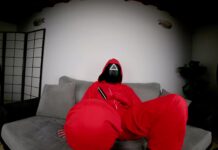 Tattooed Vixen in Red Jumpsuit Flaunts Her Bare Feet for Attention